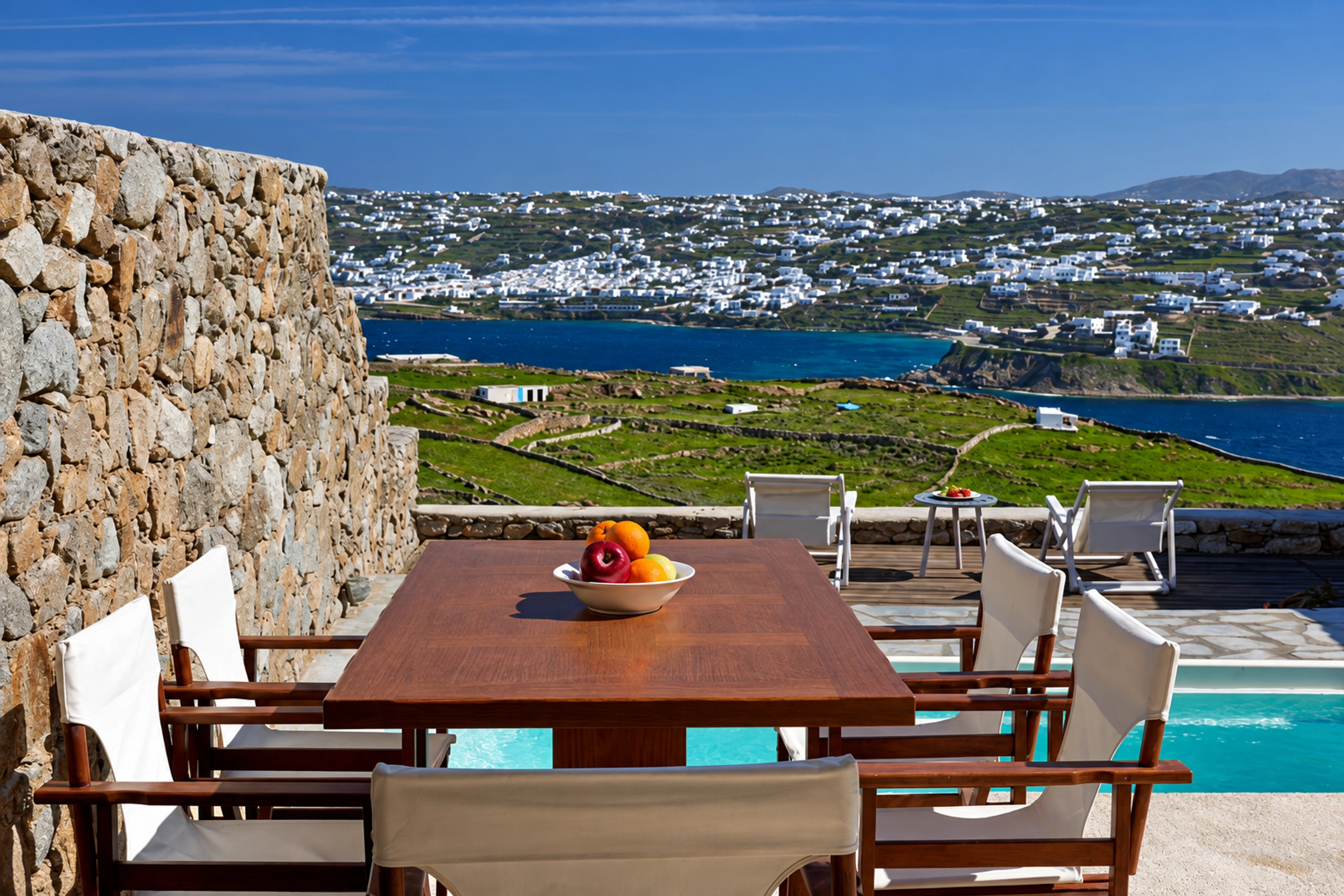 Outdoor dining table on Nalu Villa’s stone terrace with an open sea view